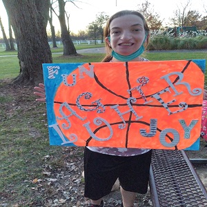 Photograph of Kara Huggins with her artwork.