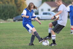 Claire playing soccer against another team.